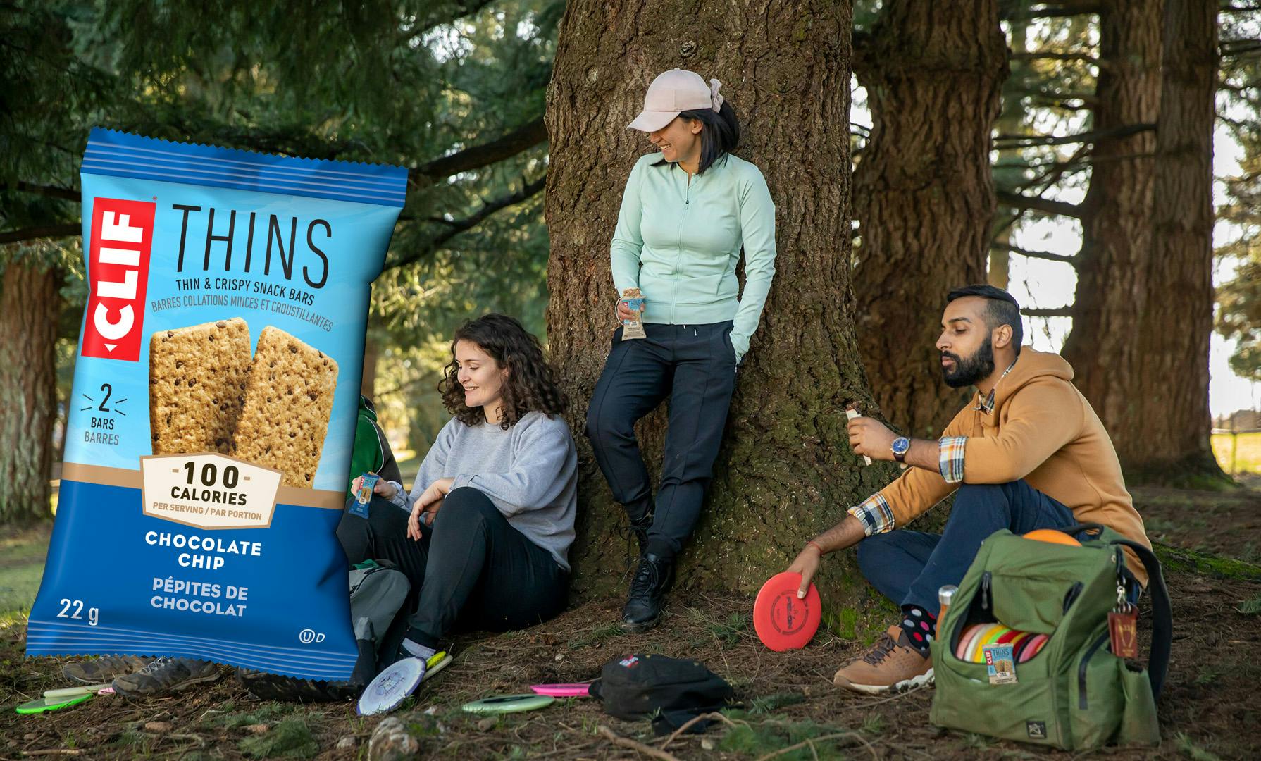 People standing near tree eating CLIF Thins