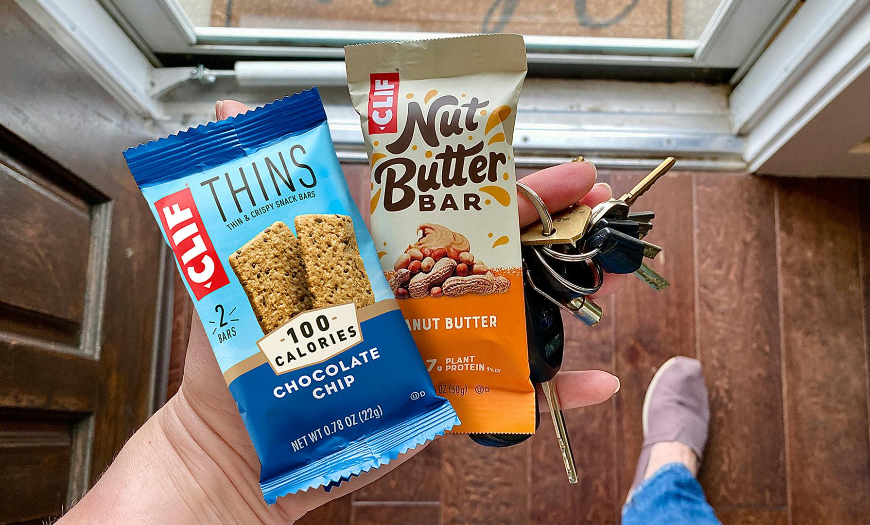 Hand holding keys, CLIF BAR, and CLIF Nut Butter Bar