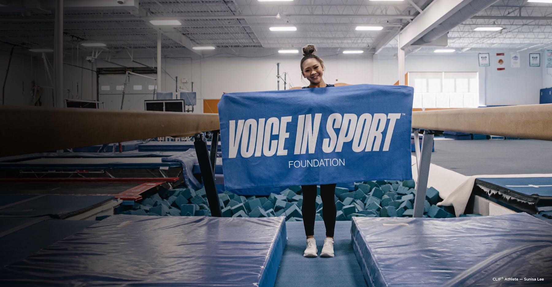 Gymnast Sunisa Lee holding Voice in Sport Banner