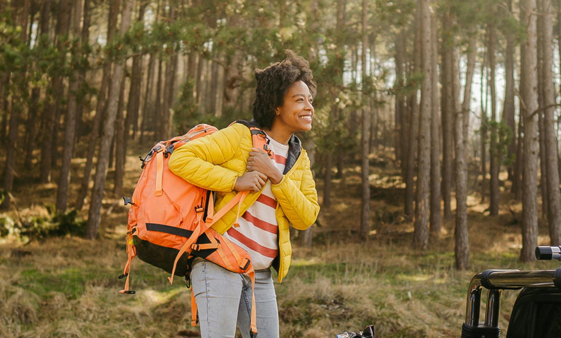 Woman in yellow jacket going backpacking