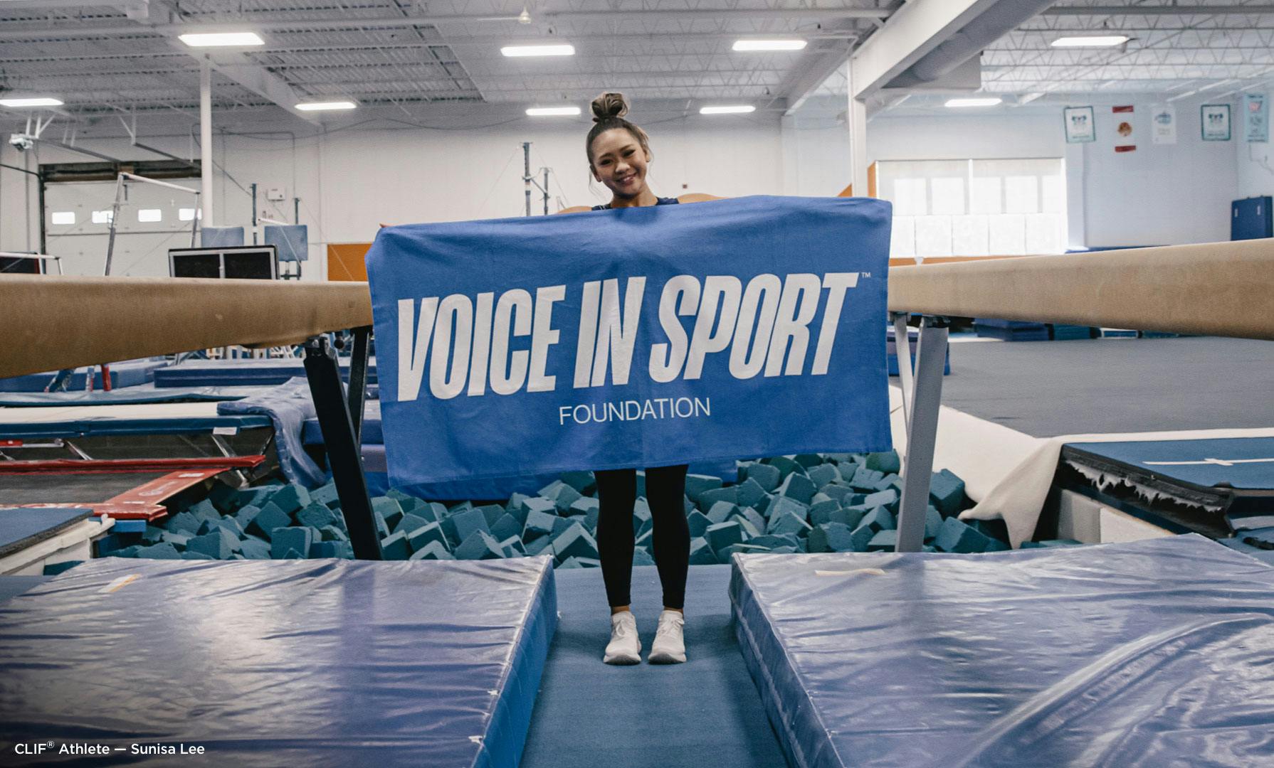Sunisa Lee Holding Voice in Sport Foundation Banner