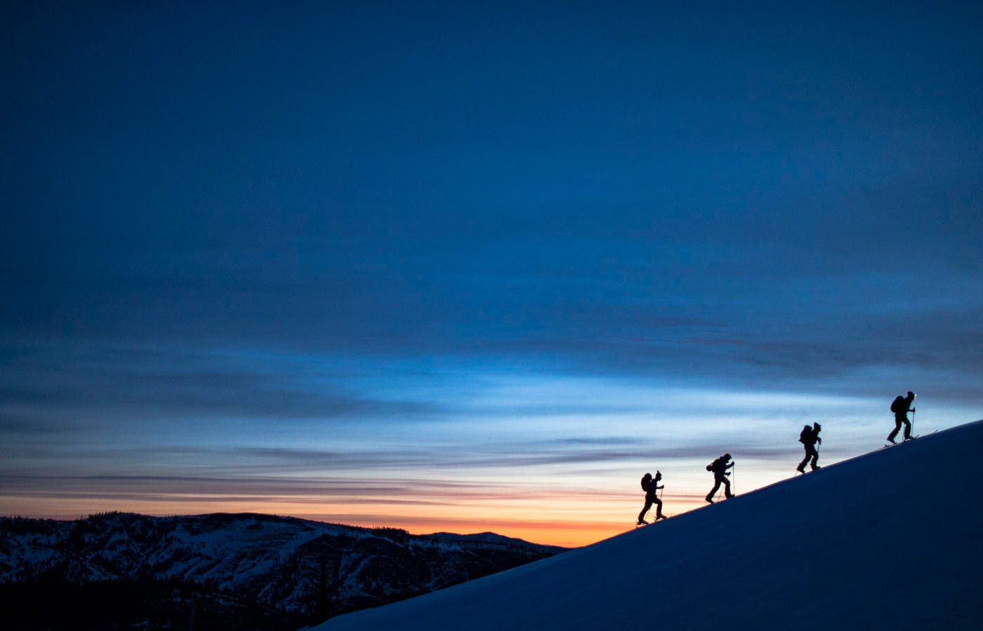 Hikers hiking up mountain at sunset