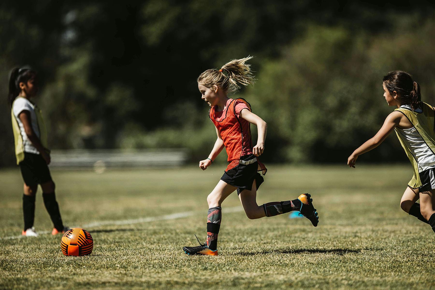 Girl in red jersey playing soccer
