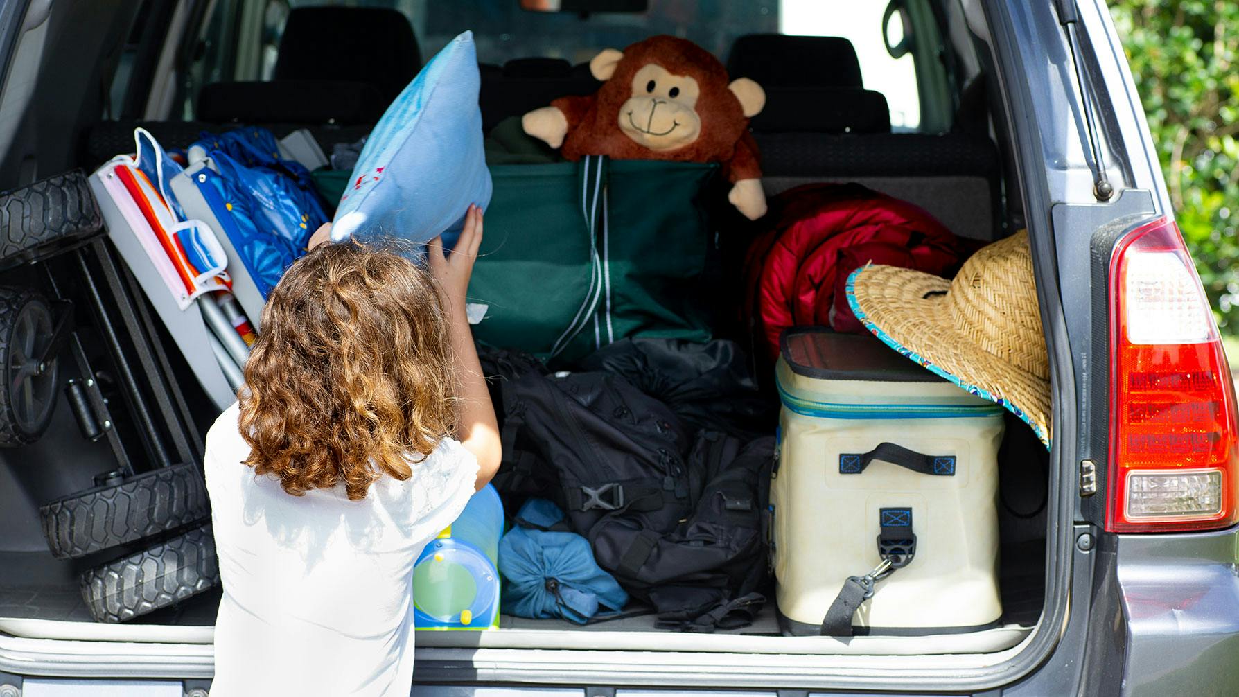 Kid packing up car for camping
