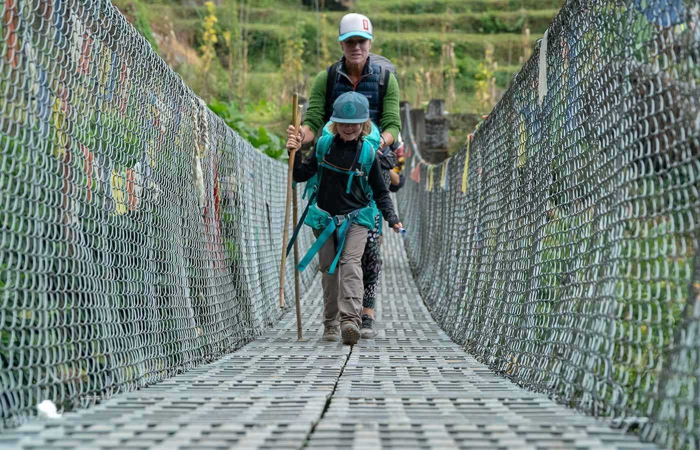 Mom and son crossing bridge in Nepal