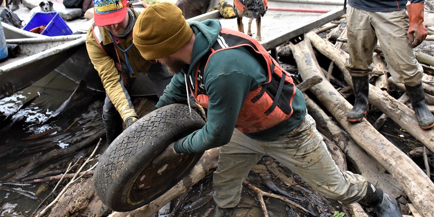 Clif Bar employee Eric Walle lifts tire out of Ohio River