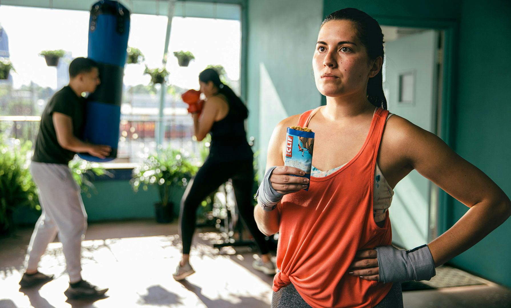 Woman eating clif bar boxing gym
